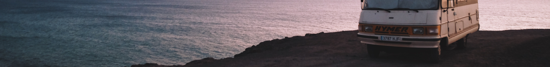 recreational vehicle parked on a cliff overlooking ocean